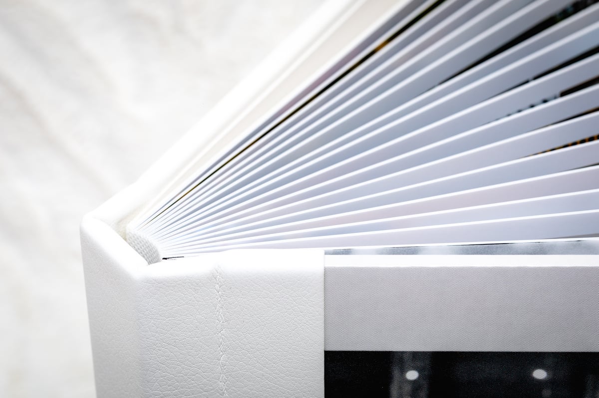 Close-up of the white album&rsquo;s fanned lay-flat pages.