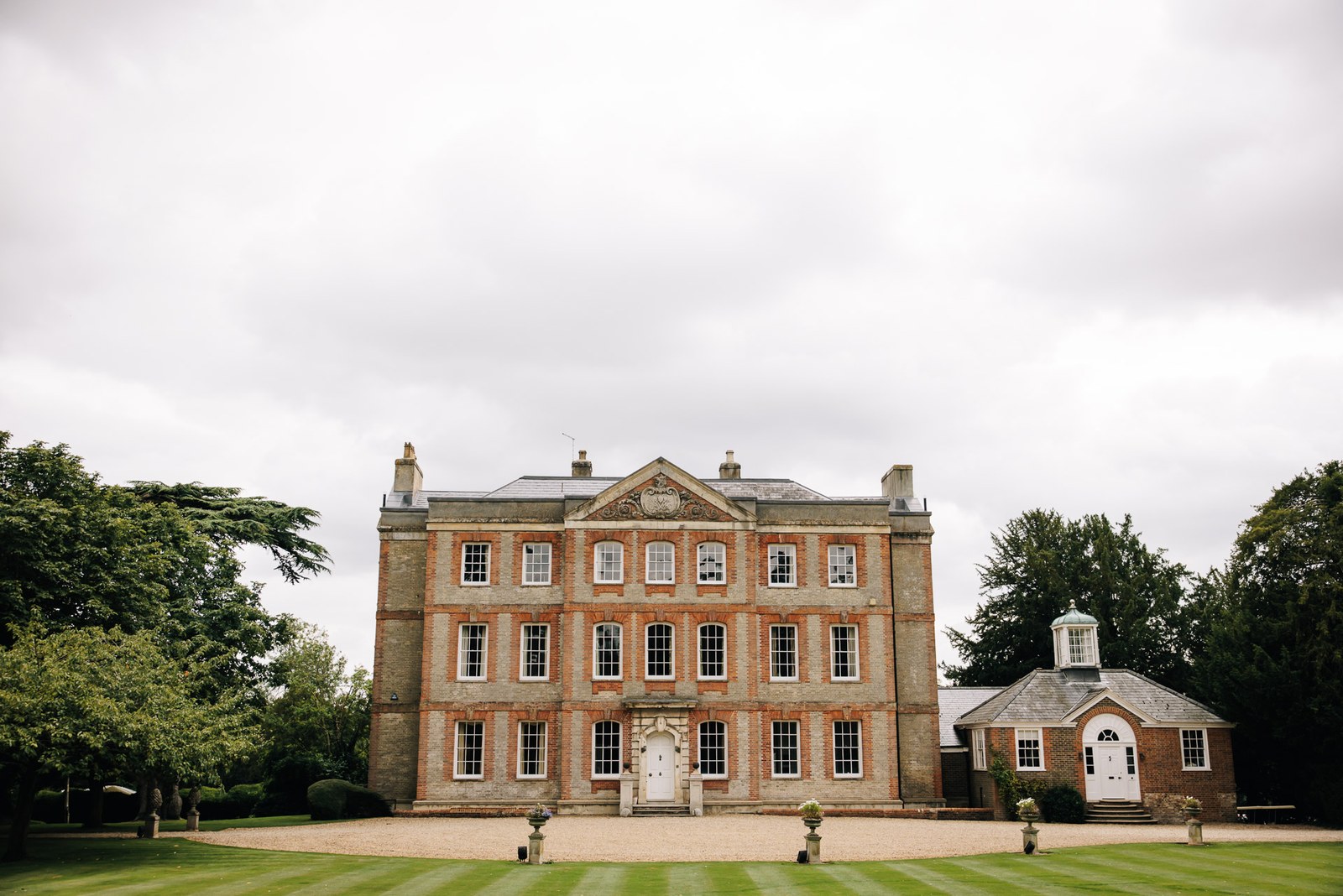 The red-brick Georgian frontage of Ardington House rising above manicured lawns