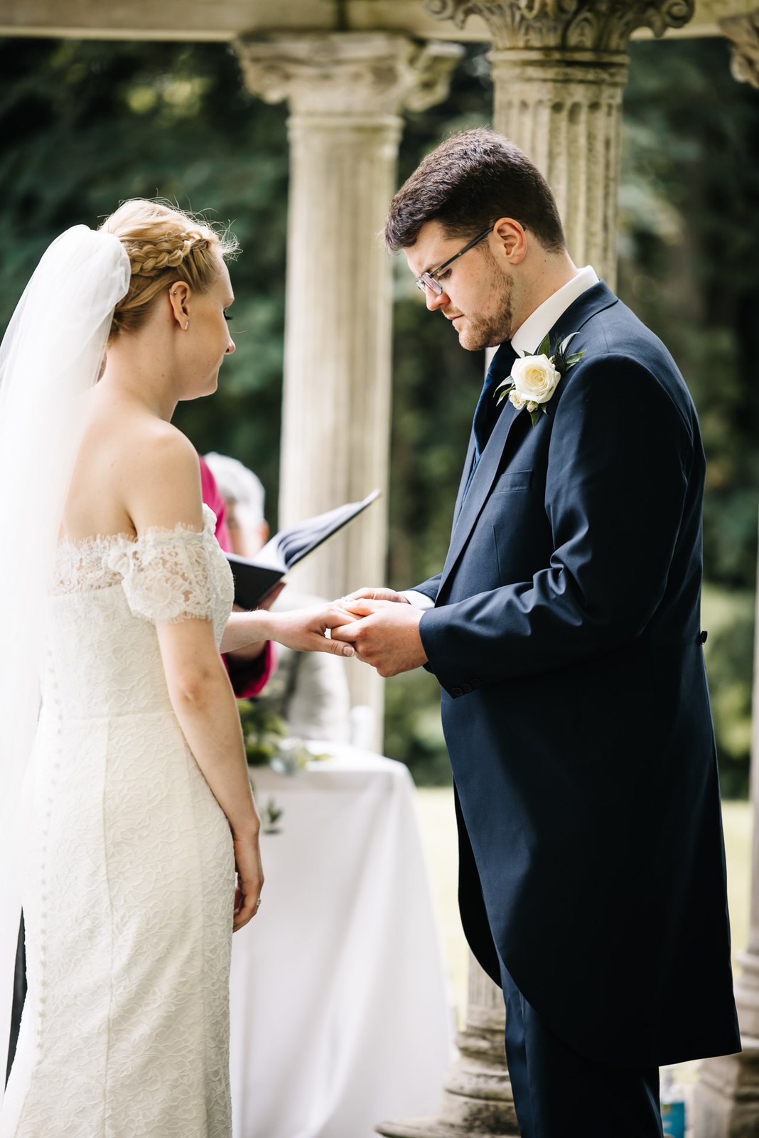 Bride and groom exchanging vows between the columns of the temple