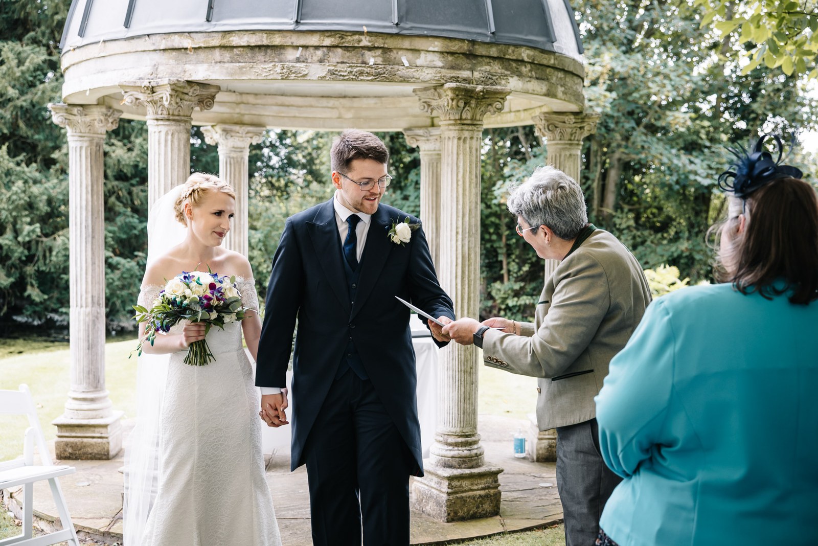 The newlyweds leaving the temple as the registrar hands over the certificate