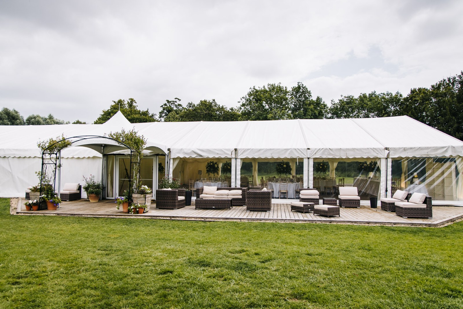 A lounge marquee with rattan seating on decking in the grounds of Ardington House