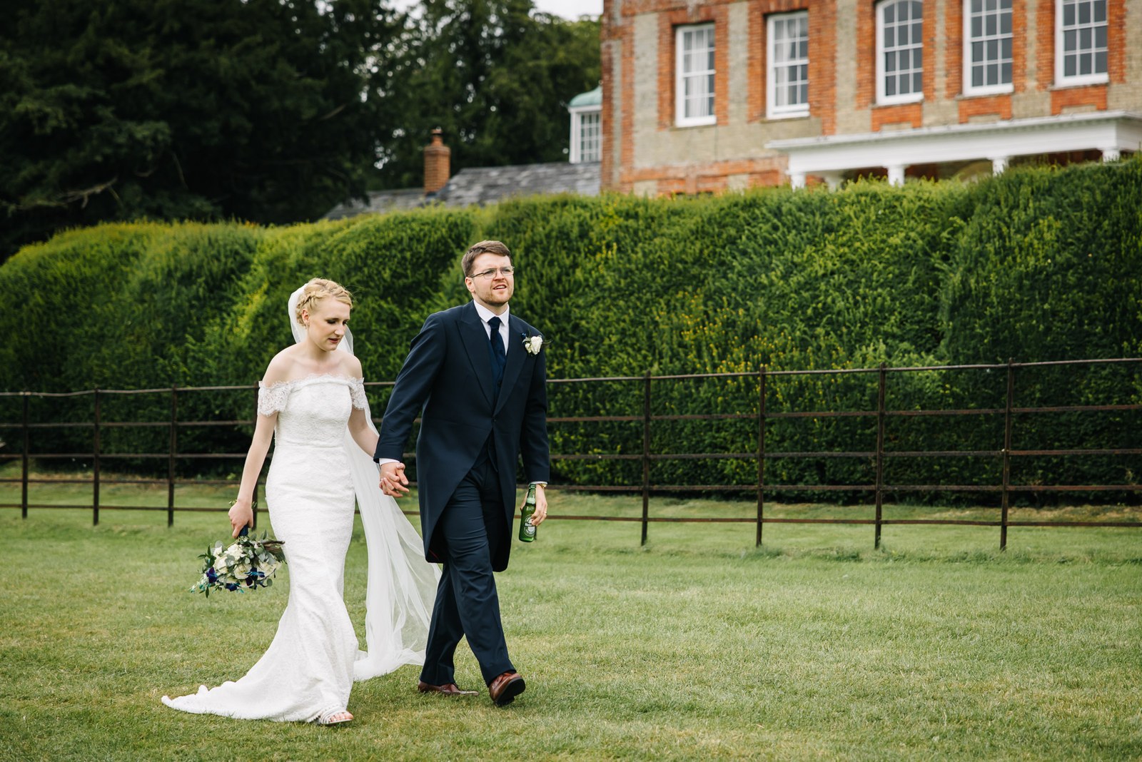 The couple walking the lawn with Ardington House and its clipped hedge behind