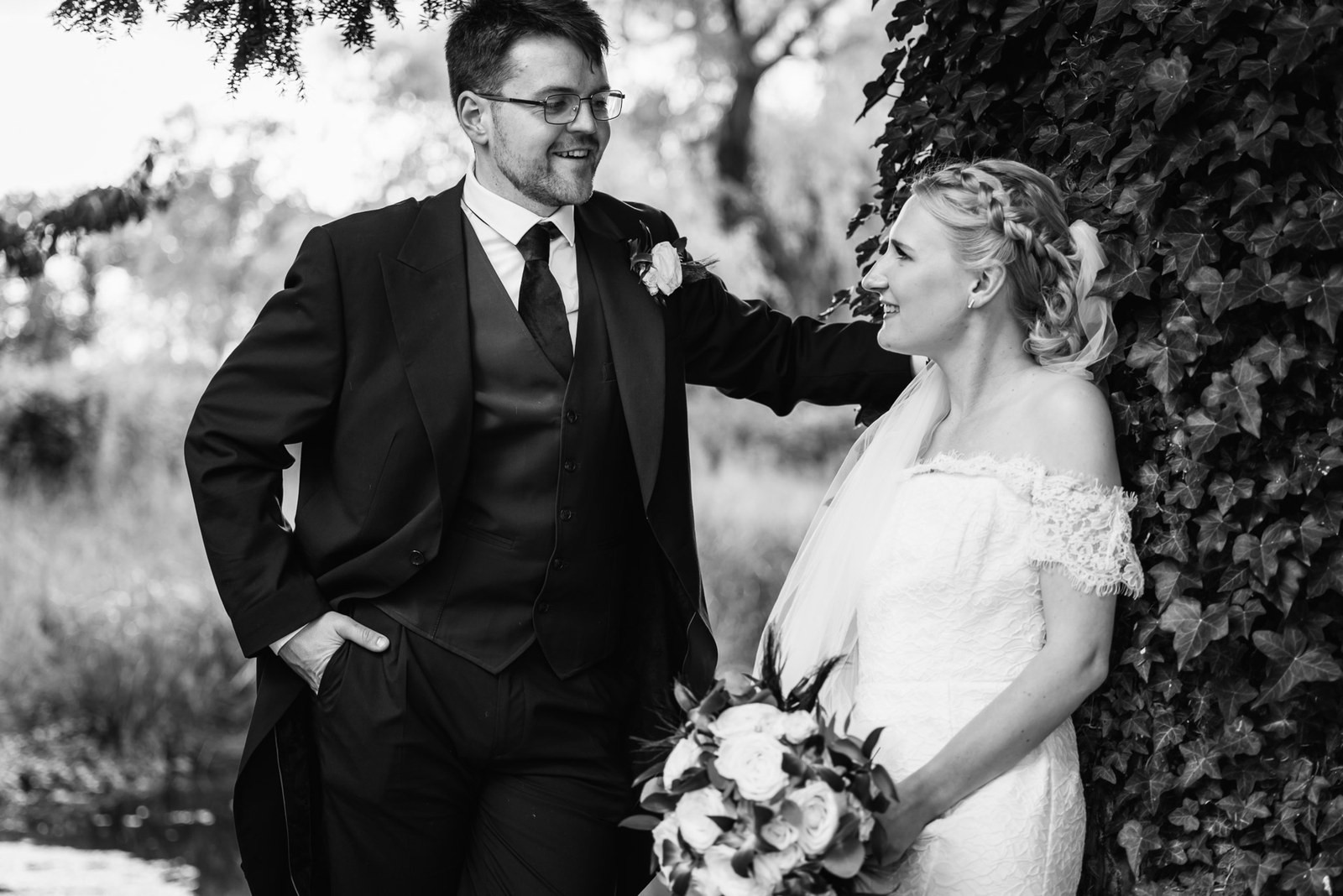 Black-and-white portrait of the couple against an ivy-clad wall