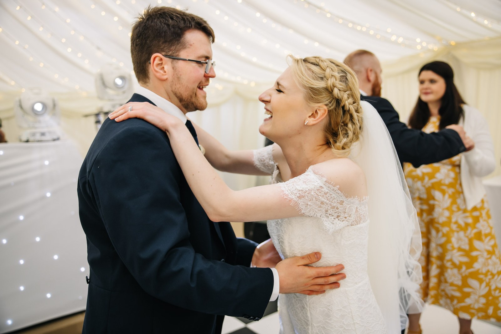 The couple sharing their first dance under fairy lights in the marquee