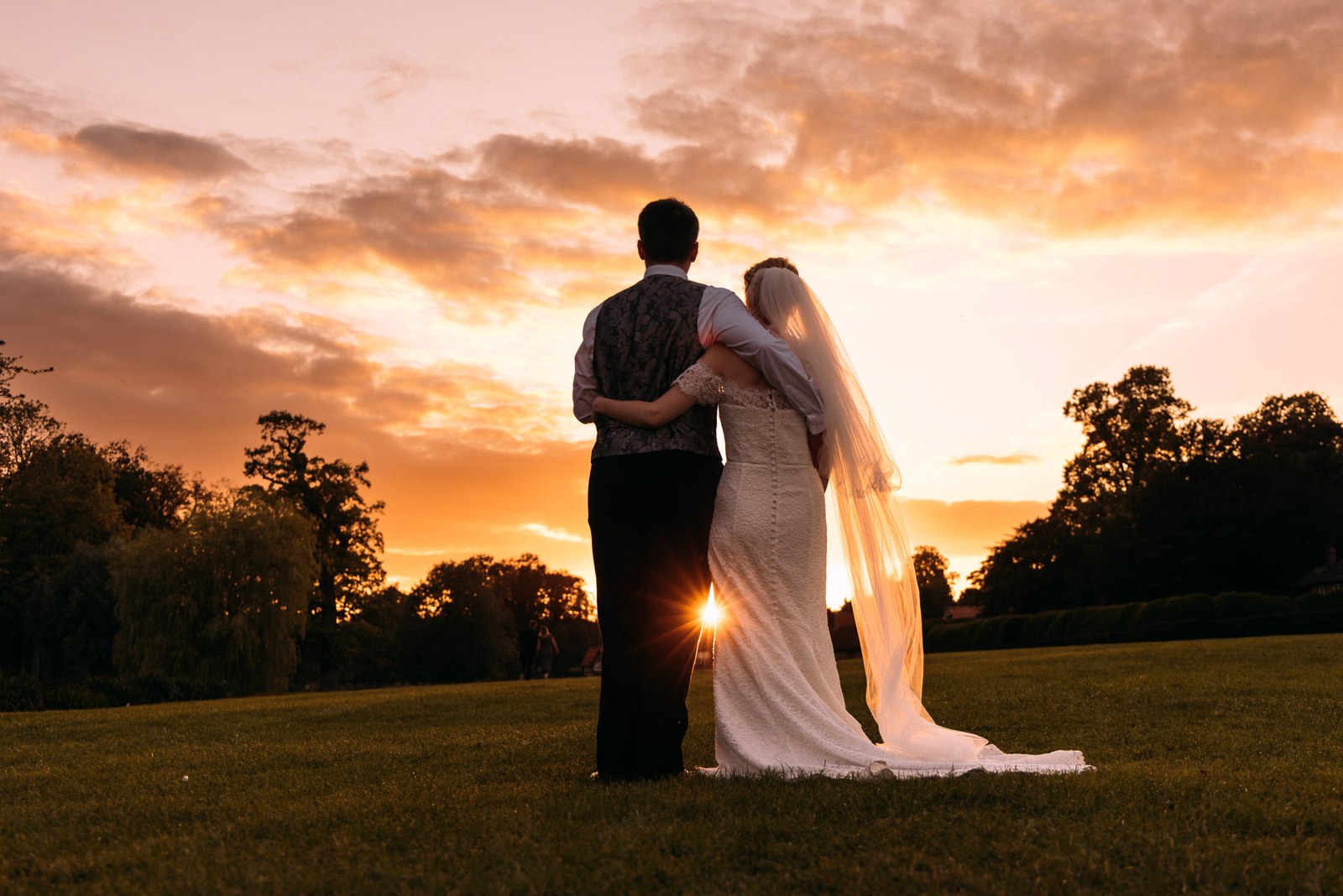 The couple silhouetted against a pink sunset in the grounds of Ardington House