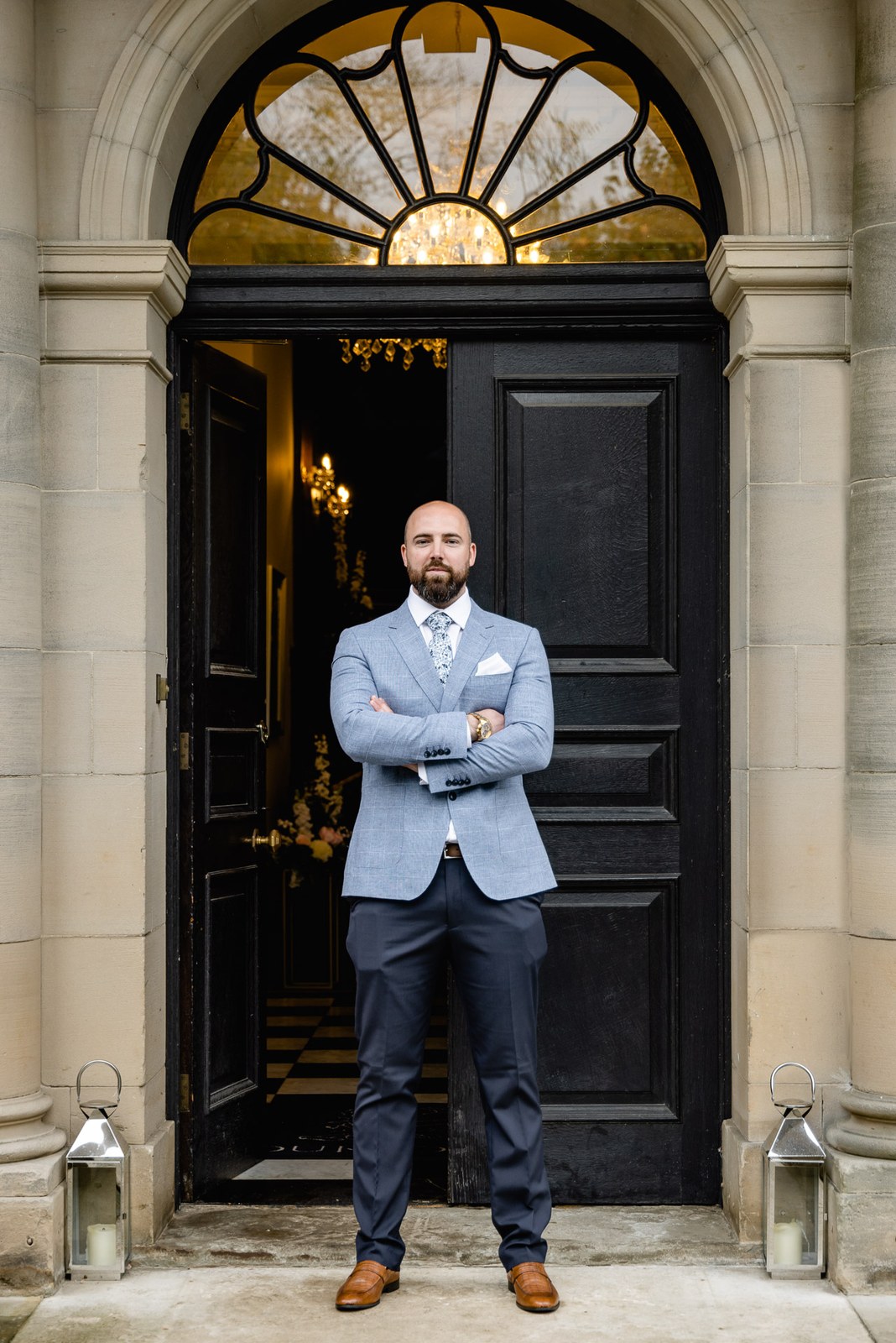 The groom standing in the grand arched entrance doorway of Bourton Hall