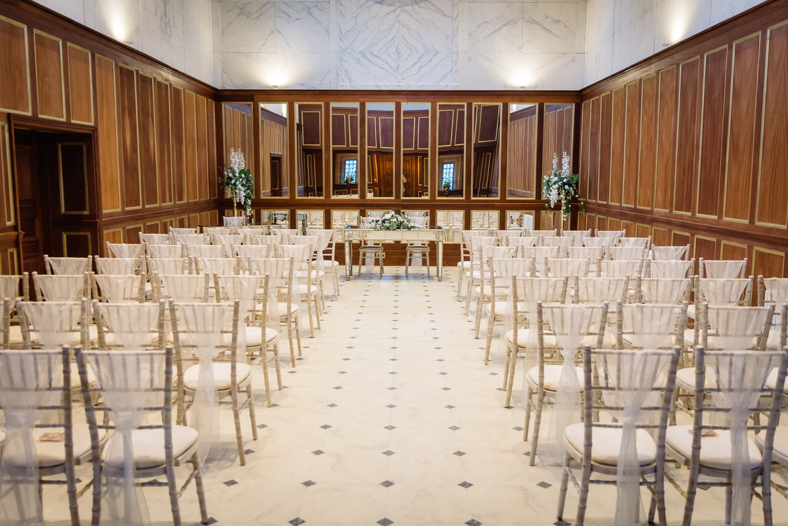The wood-panelled ceremony room at Bourton Hall set with chairs and an aisle
