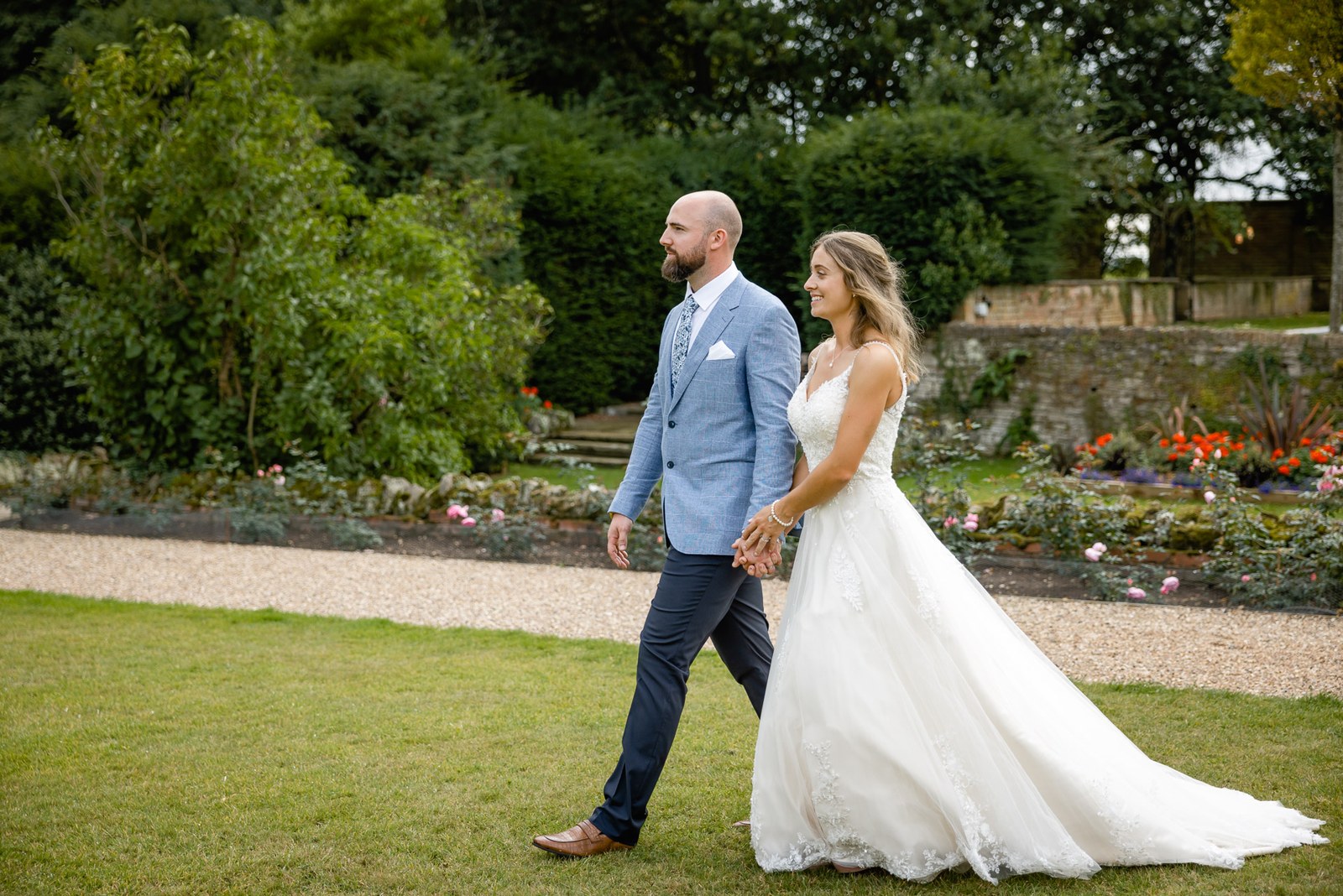 The couple strolling through the formal flower borders of the gardens