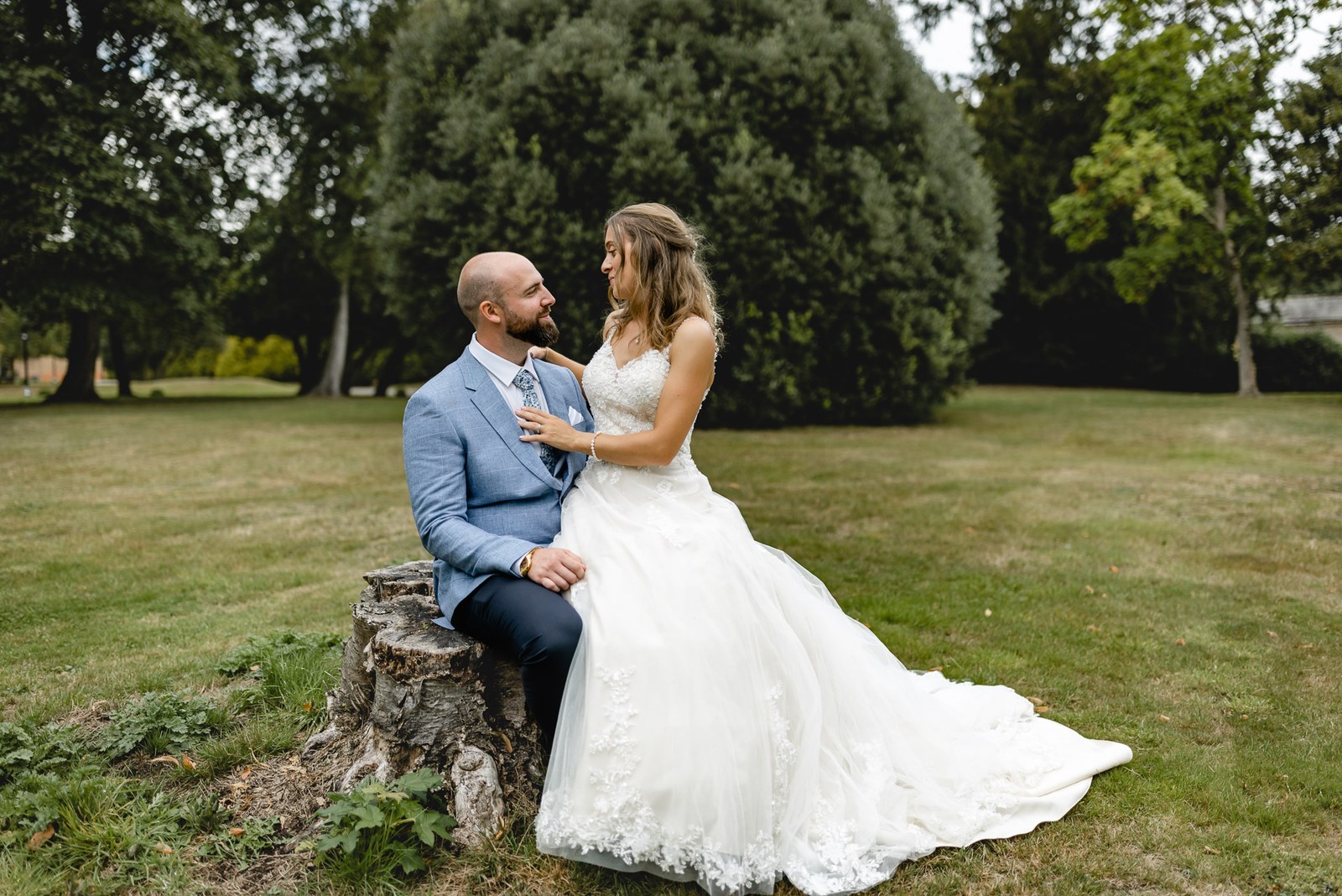 The couple resting on a tree stump in the garden, gazing at each other