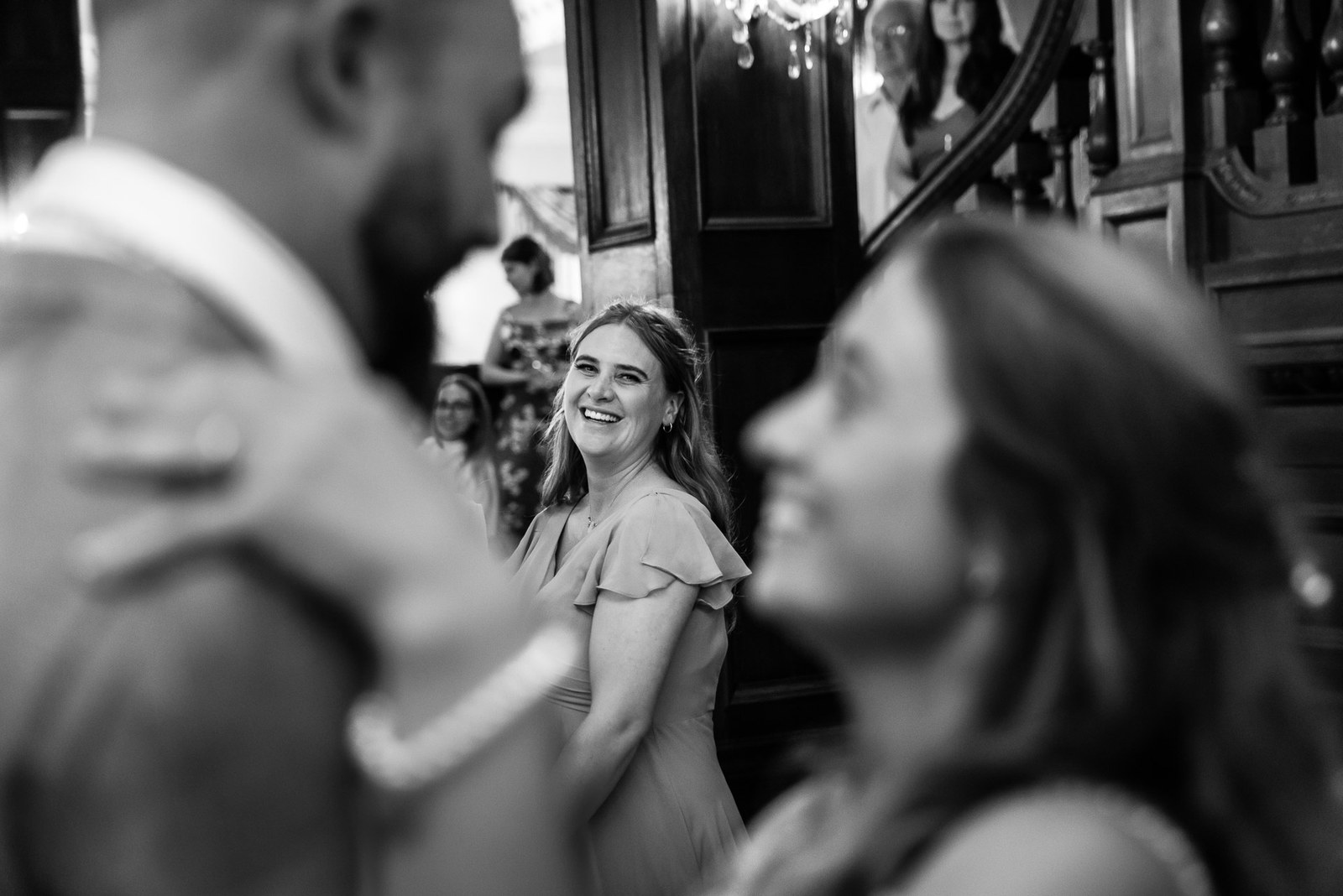 Black-and-white first dance with a smiling bridesmaid behind