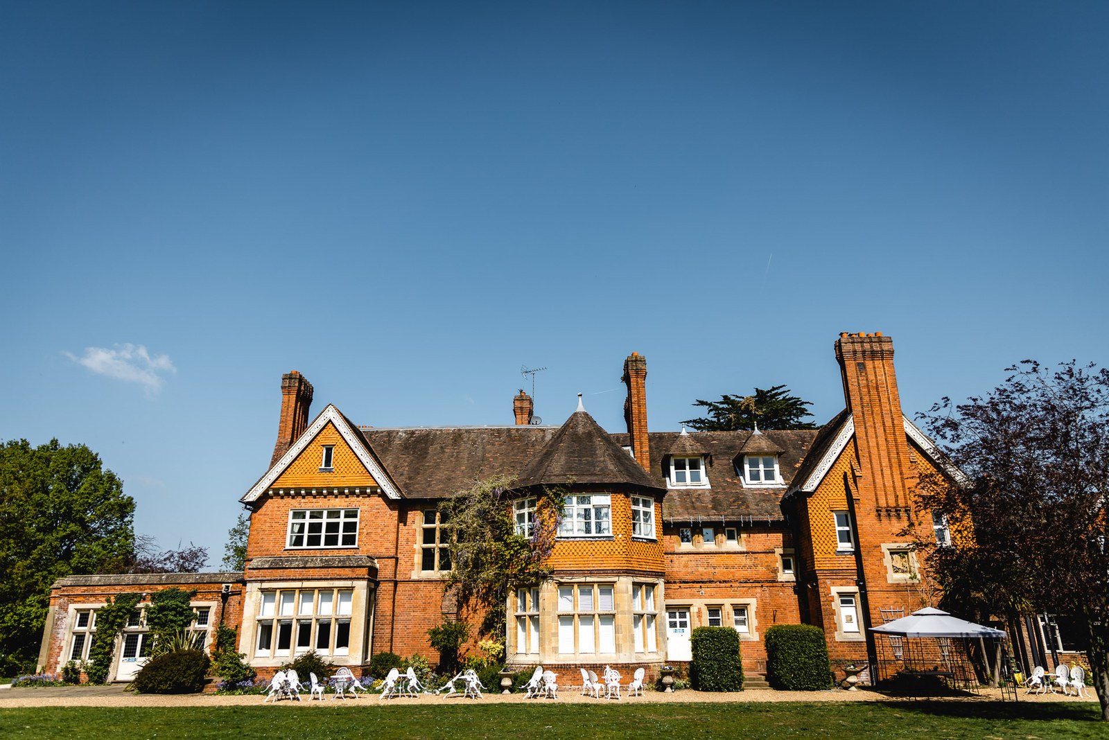 The red-brick Victorian frontage of Cantley House Hotel above its lawns under a blue sky