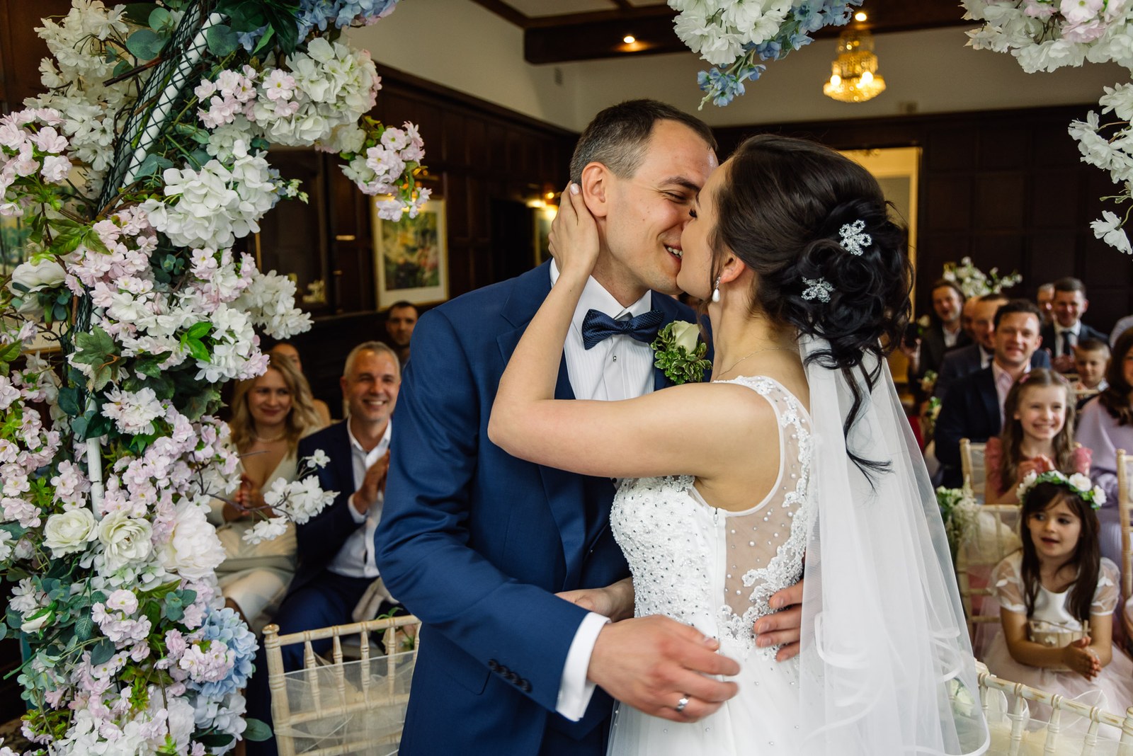The couple's first kiss beneath the blossom arch