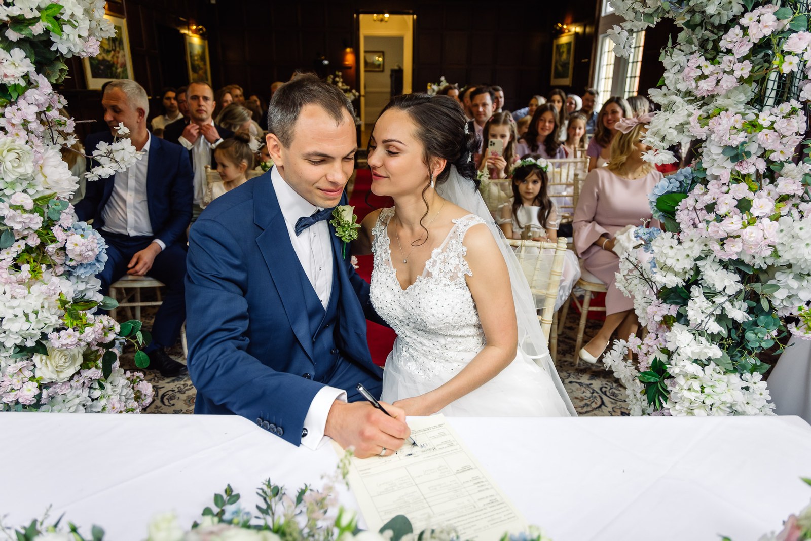 Bride and groom signing the register at the ceremony