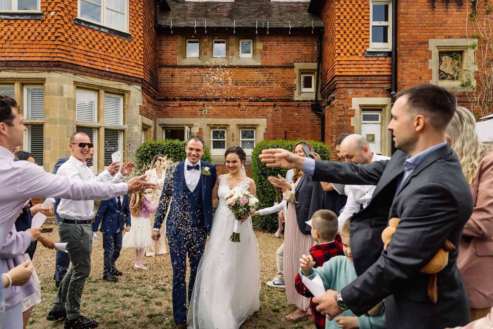 Confetti thrown over the couple outside the brick facade of Cantley House Hotel