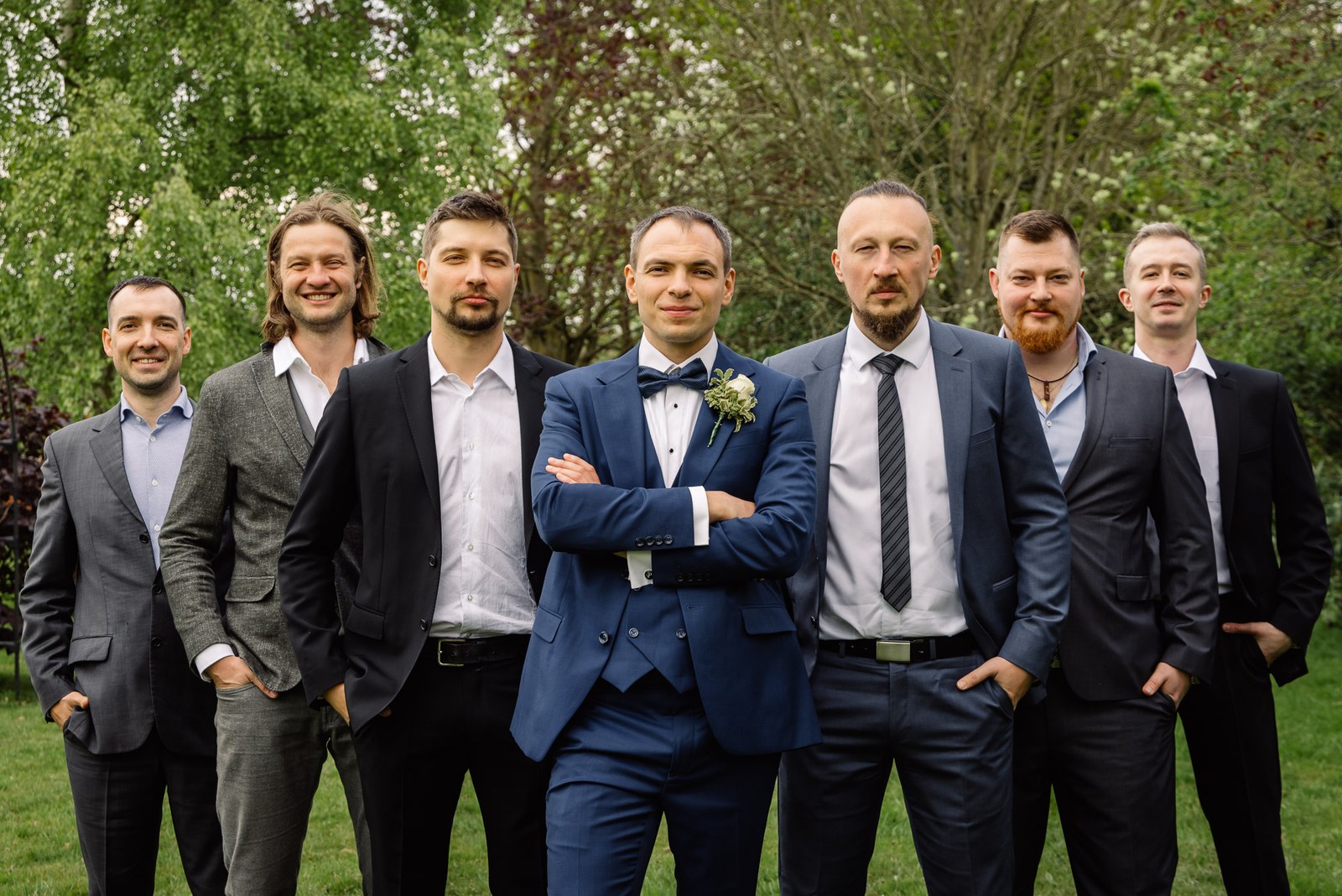The groom with his groomsmen posing together on the lawn