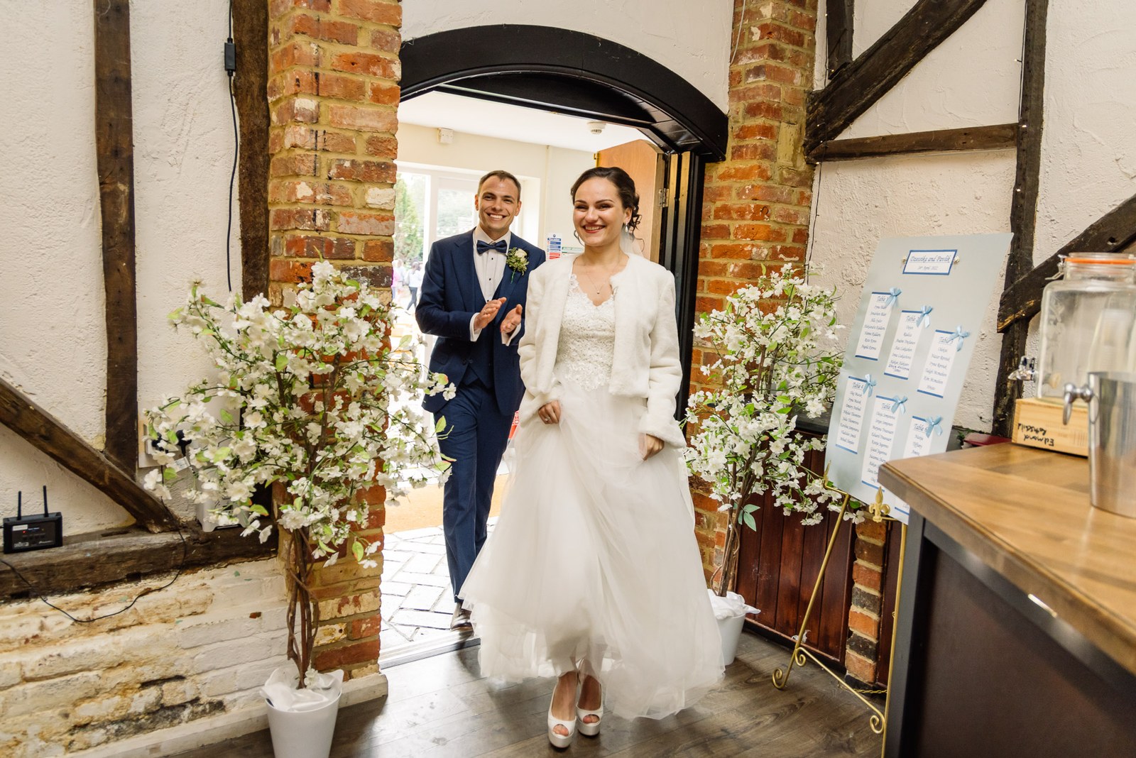 The newlyweds entering the reception through the beamed archway at Cantley House Hotel
