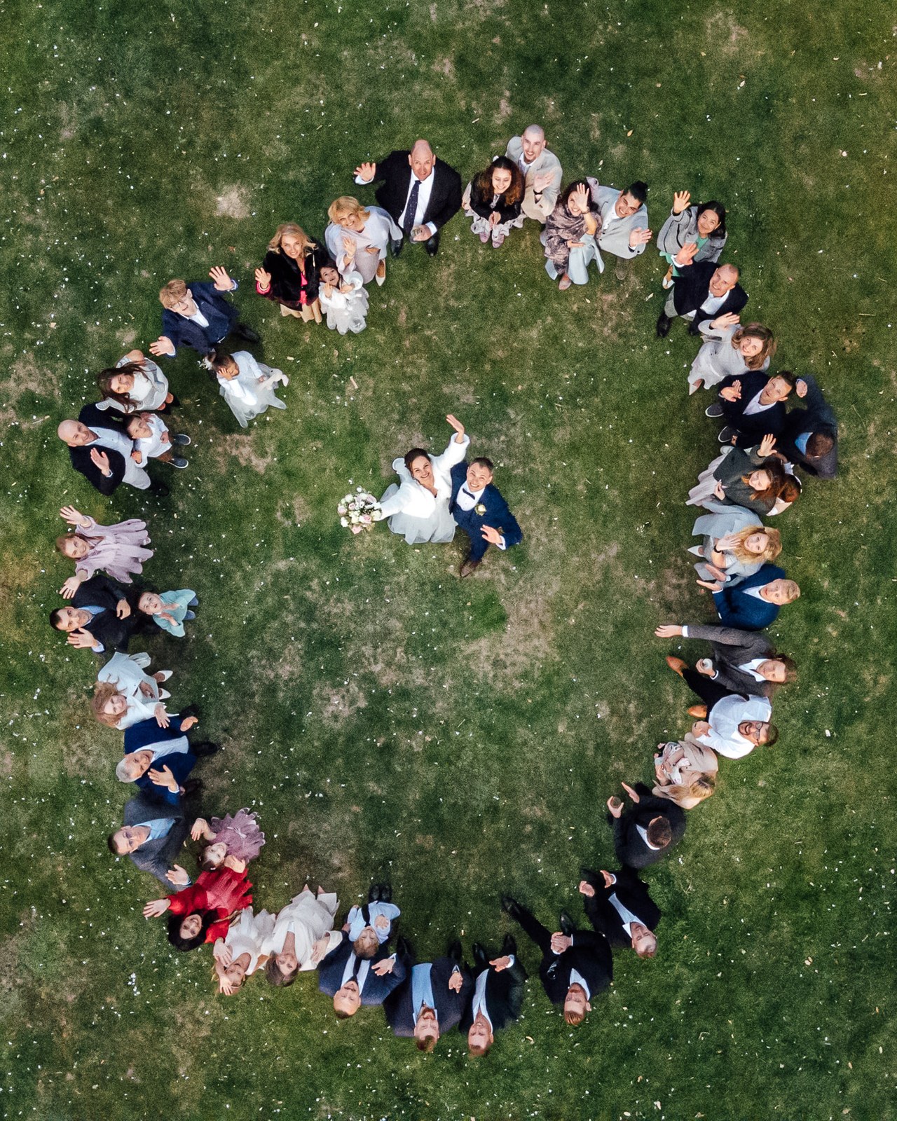 An aerial view of guests forming a heart around the couple on the lawn