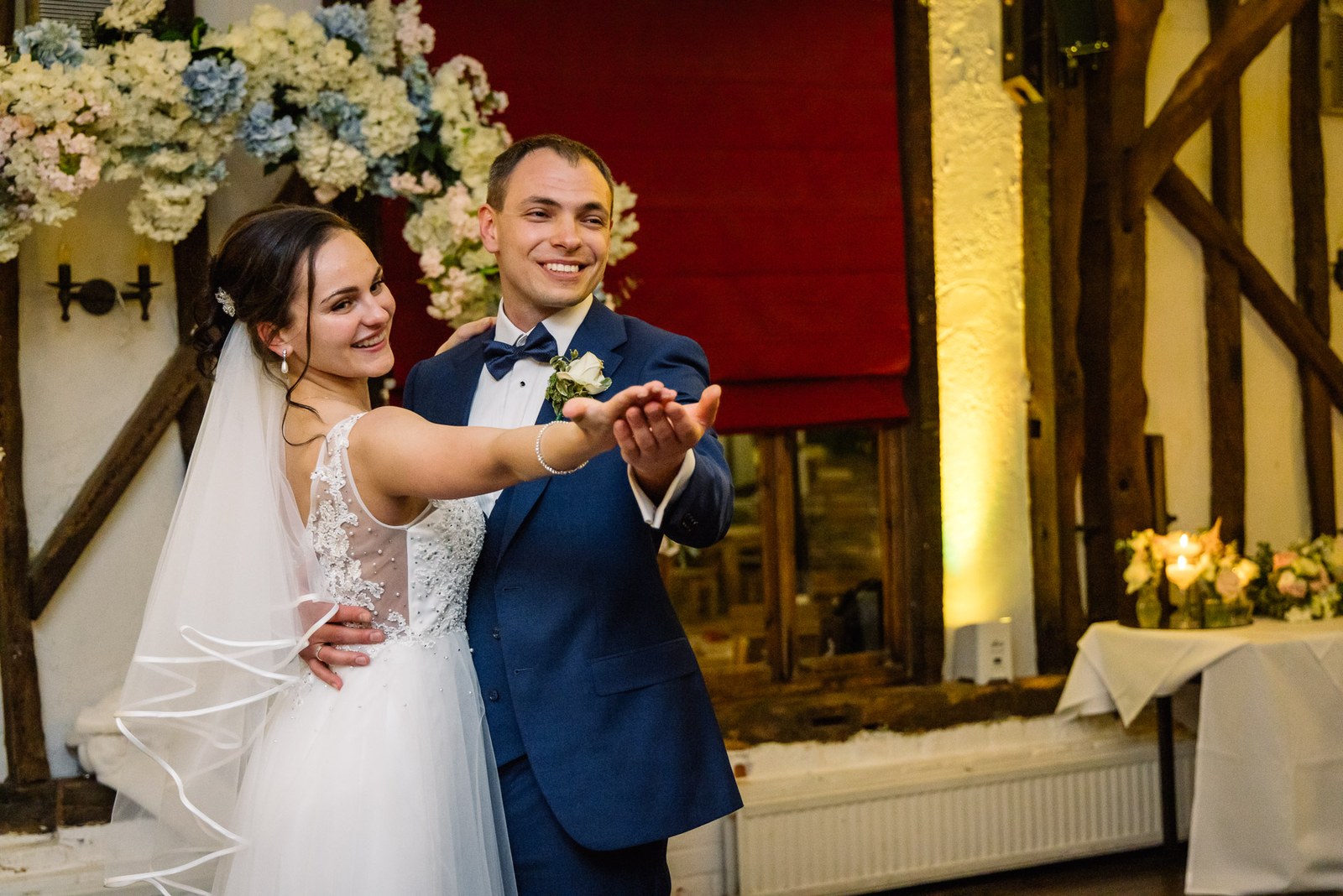 Bride and groom dancing hand in hand in the beamed hall