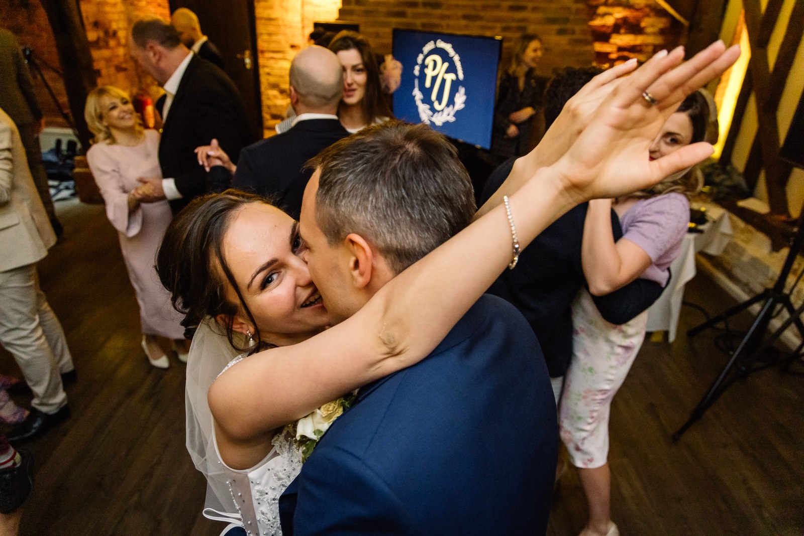 The couple dancing among their guests, arms raised