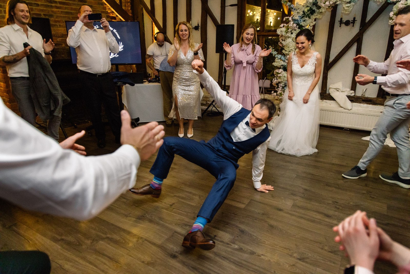 A guest throwing an energetic dance move as others cheer