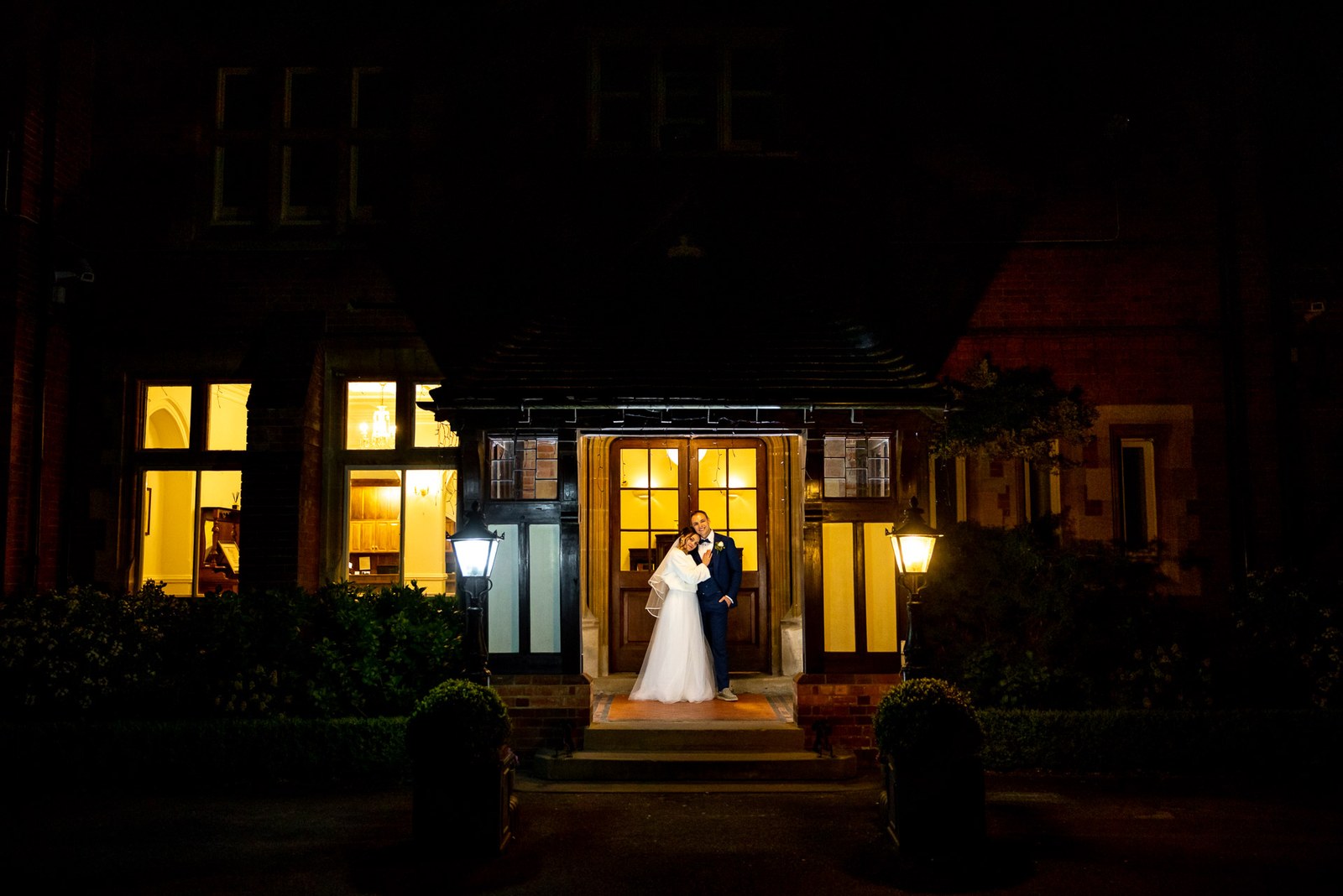 Cantley House Hotel at night, the couple embracing in the glowing doorway
