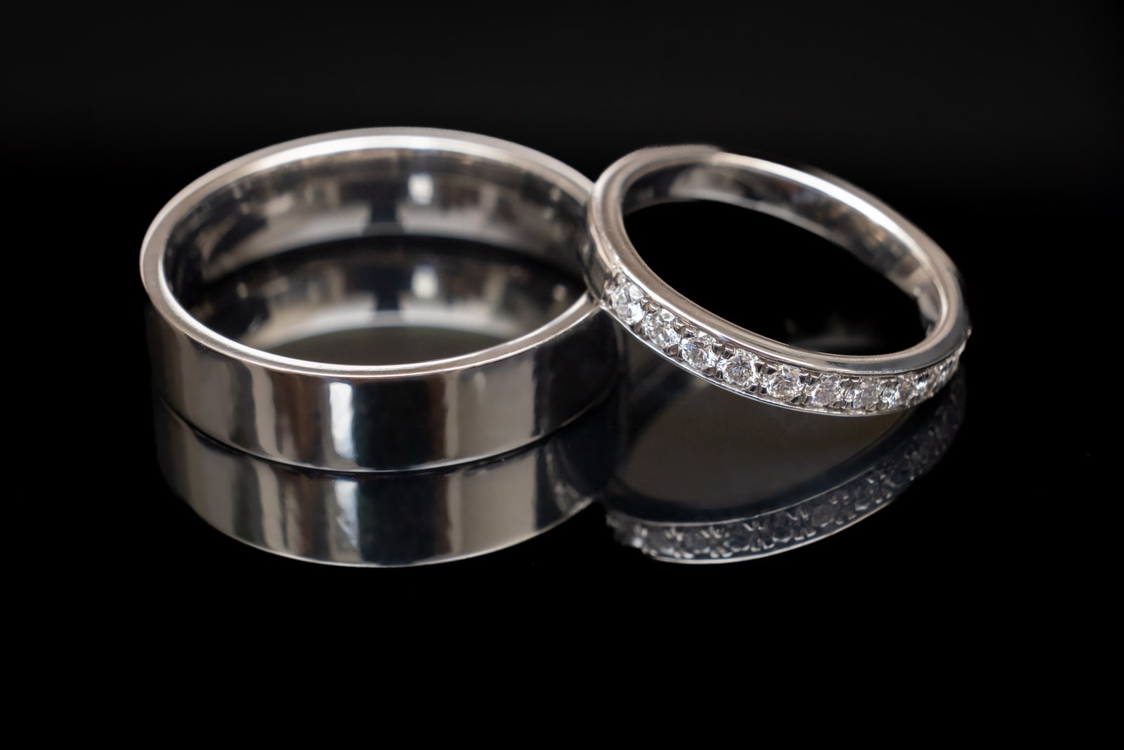 Close-up of a plain wedding band beside a diamond eternity ring