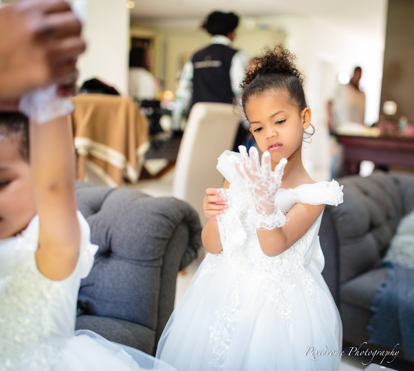 Two flower girls pulling on their lace gloves before the ceremony