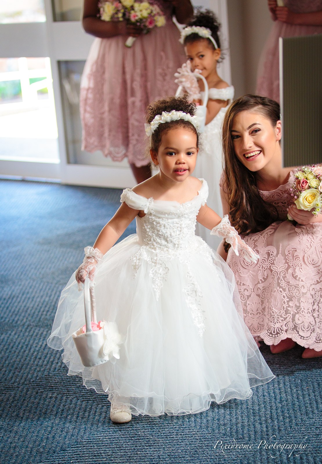 A bridesmaid and flower girl entering, the little one with a petal basket