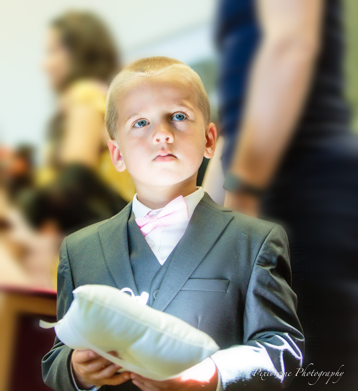 A page boy holding the ring cushion, close-up