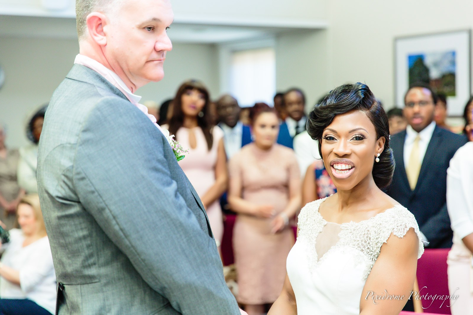 The couple standing side by side at the ceremony, the bride beaming