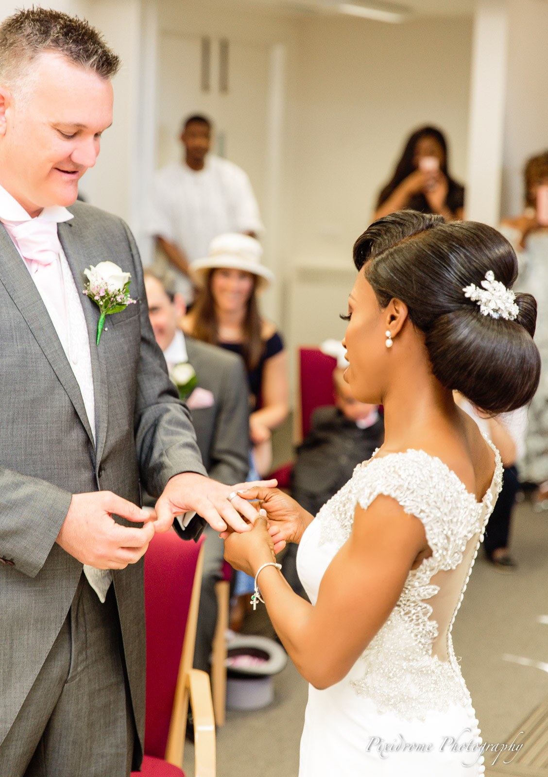 The groom sliding the ring onto the bride's finger during the ceremony
