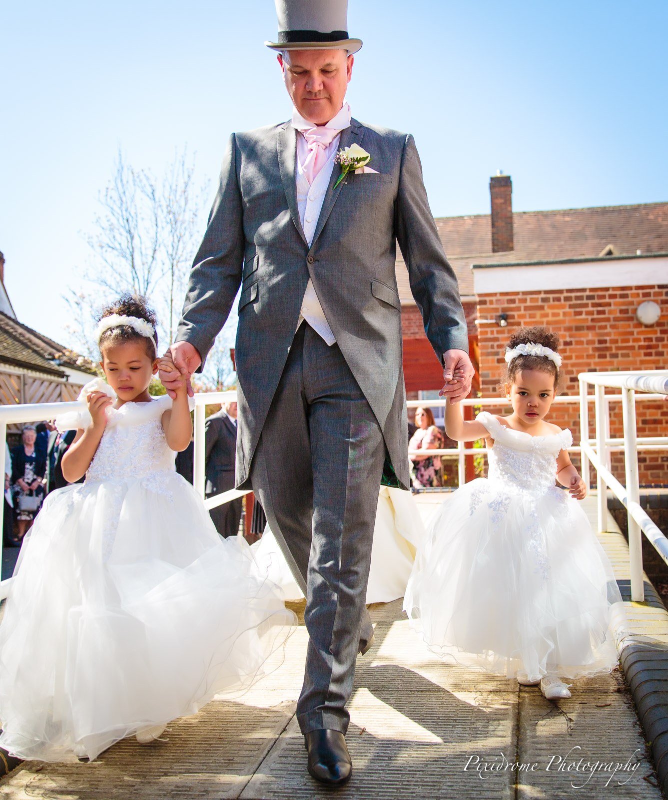 The groom leaving the ceremony with two flower girls down a ramp