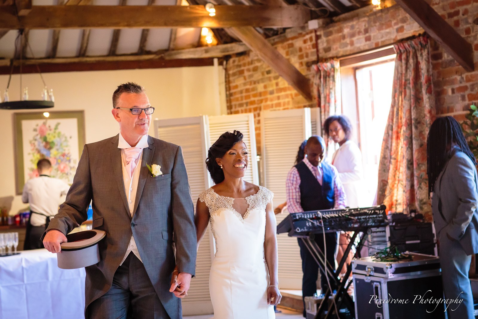 The newlyweds entering the Chenies Manor House reception, the groom holding his top hat