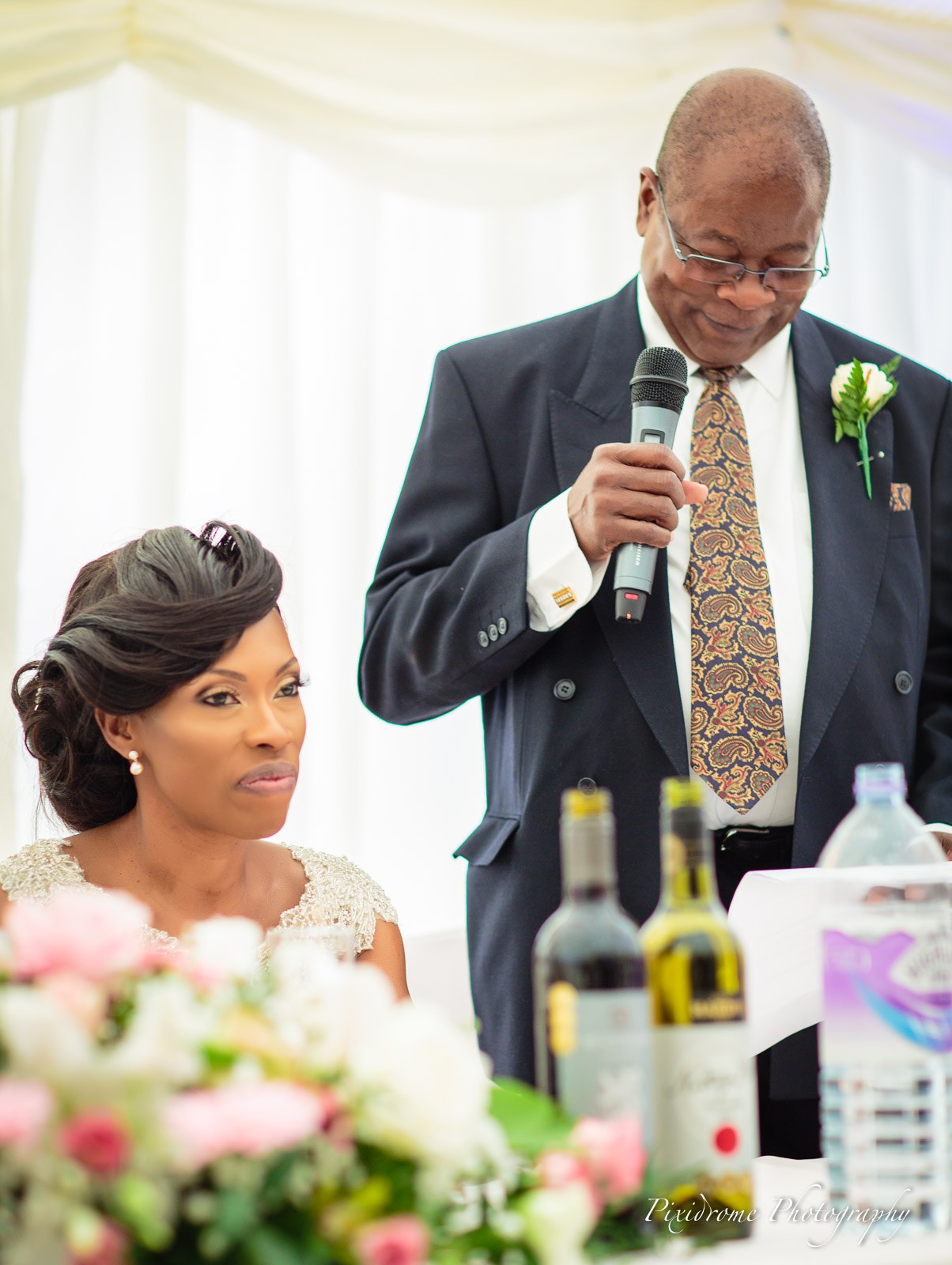The father of the bride giving his speech as the bride listens