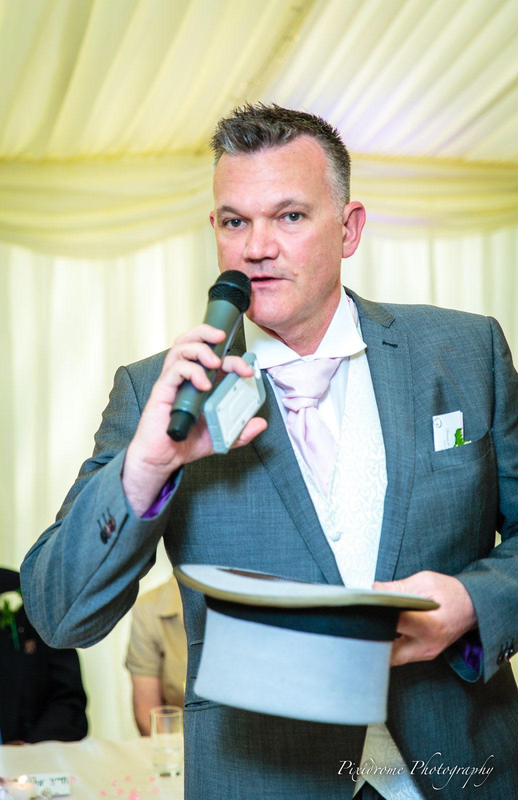 The groom giving his speech, top hat and microphone in hand