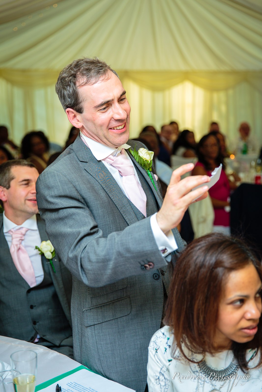 A speaker gesturing through his speech as guests listen