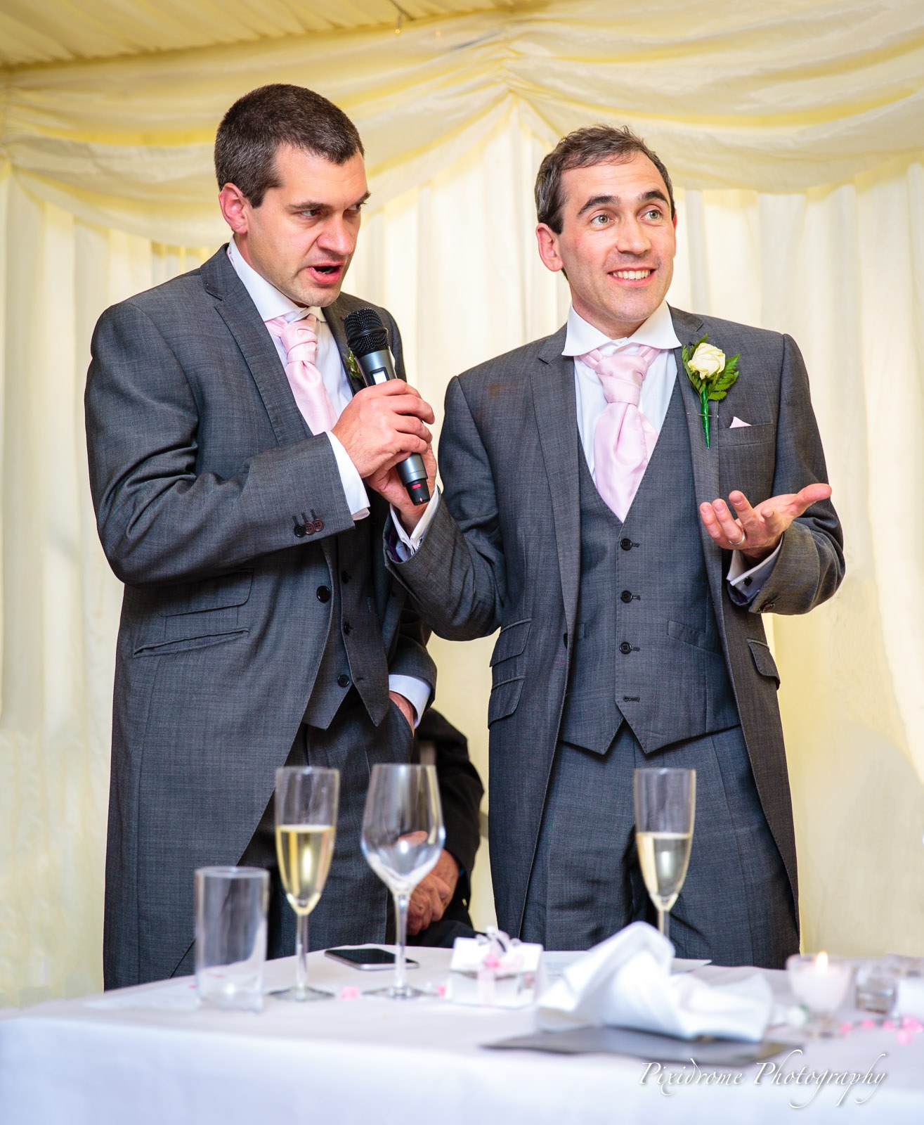 The best man delivering his speech next to a groomsman