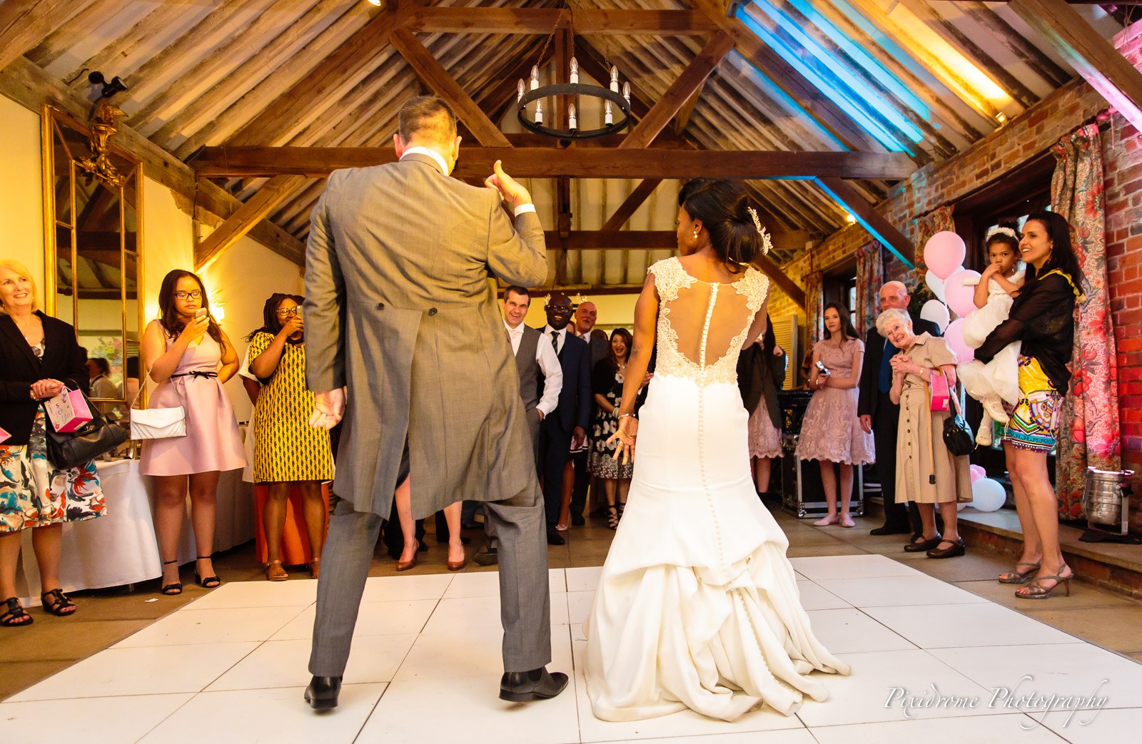 The newlyweds dancing as guests watch in the beamed hall at Chenies Manor House