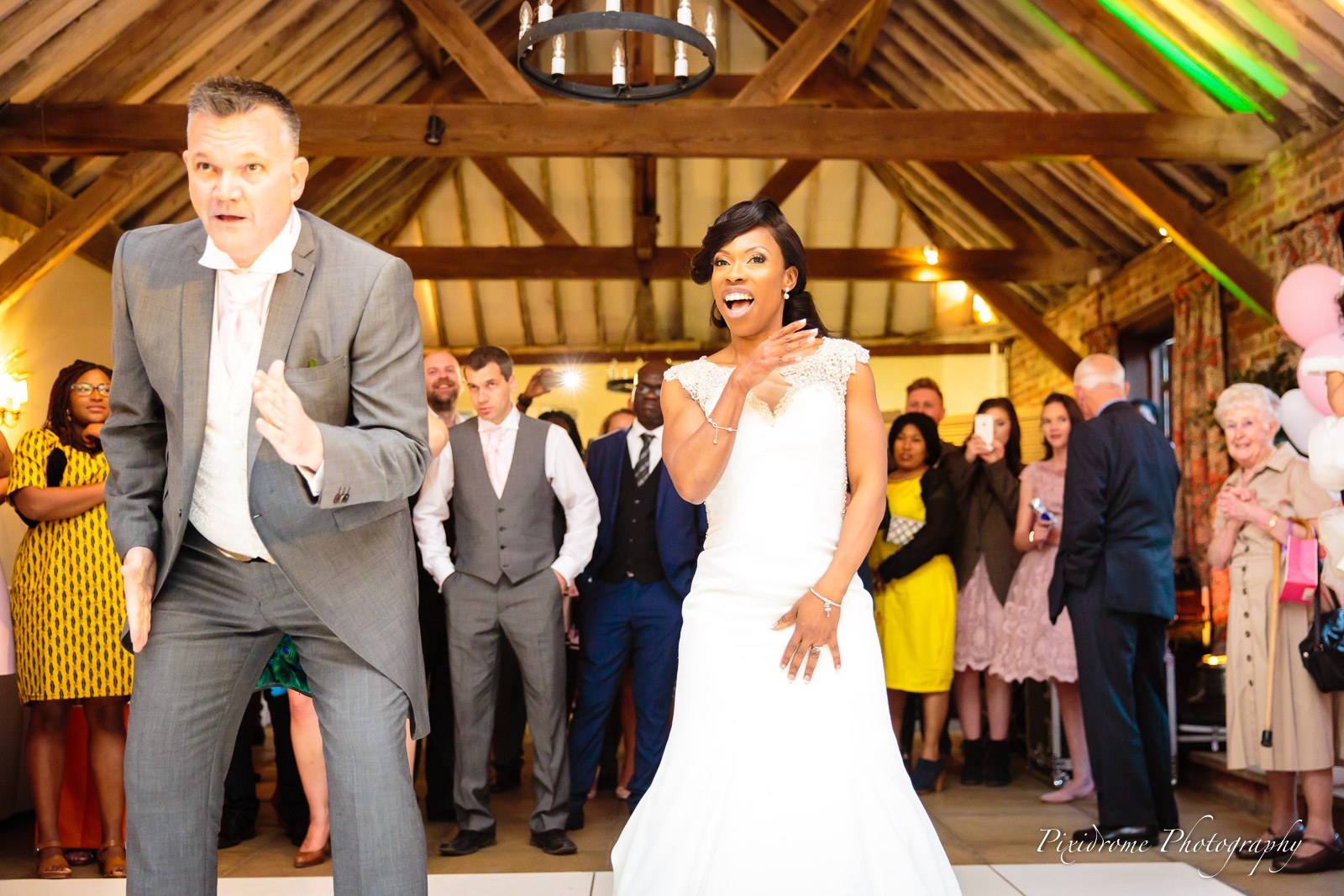 The groom throwing an energetic dance move as the bride laughs