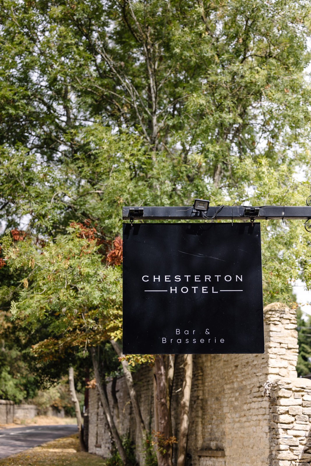 The Chesterton Hotel sign hanging by a stone wall at the entrance
