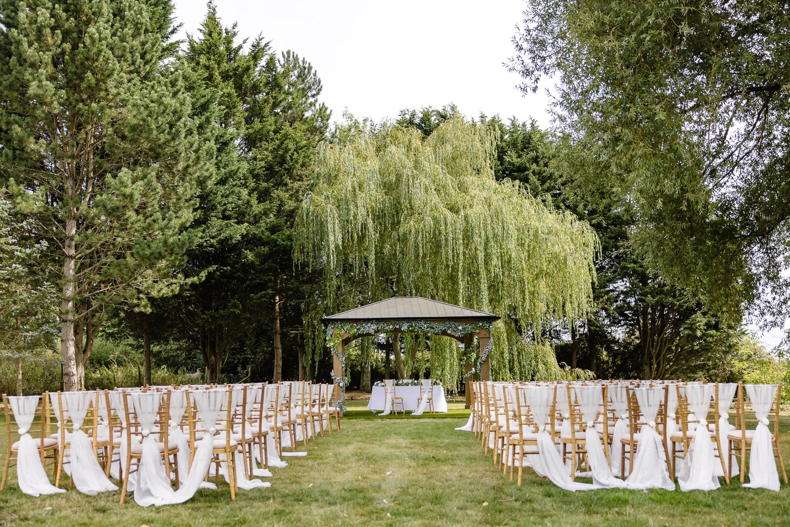 The outdoor ceremony at the Chesterton Hotel set with white chairs and a flower-topped gazebo