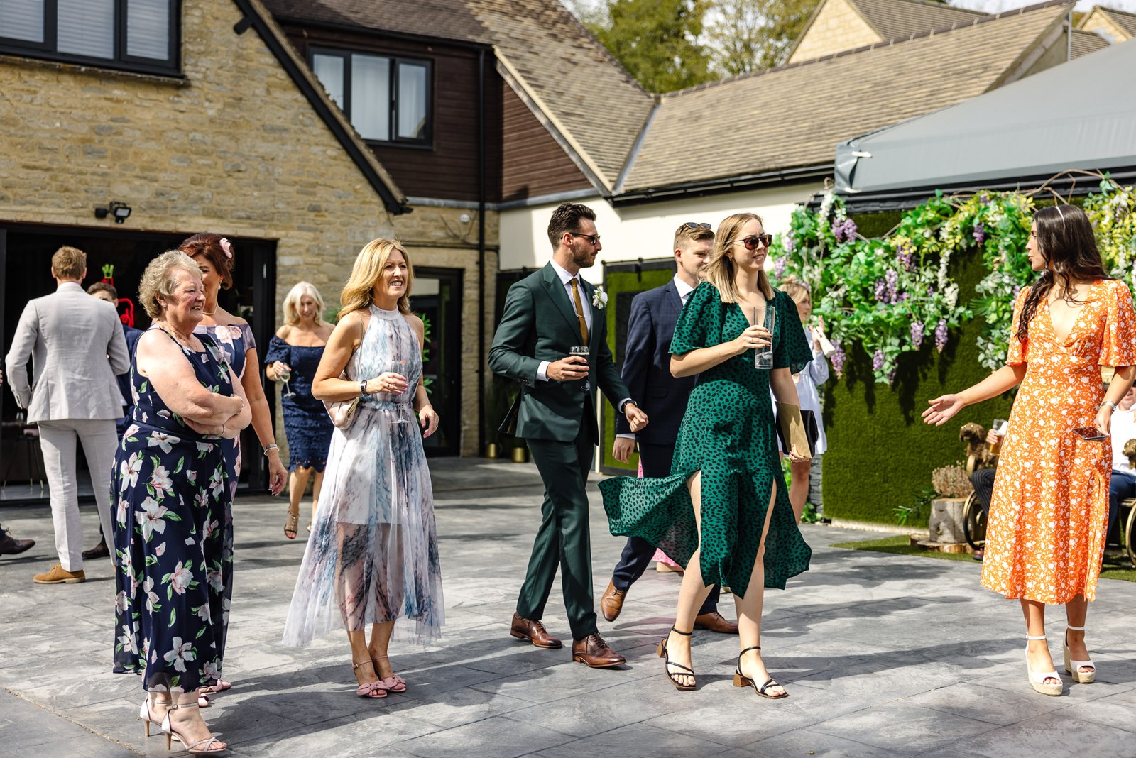 Guests arriving on the terrace beside a foliage wall at the Chesterton Hotel