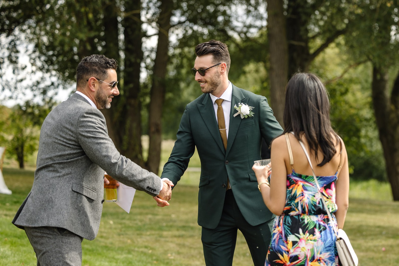 The groom in a green suit greeting guests on the lawn at the Chesterton Hotel