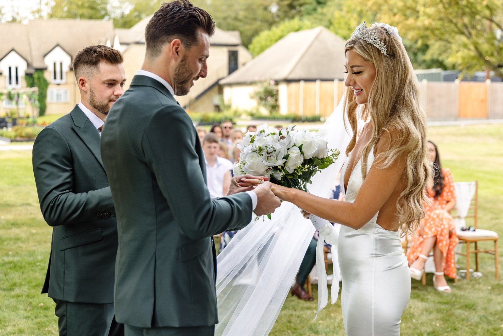 The groom sliding the ring onto the bride's finger at the ceremony