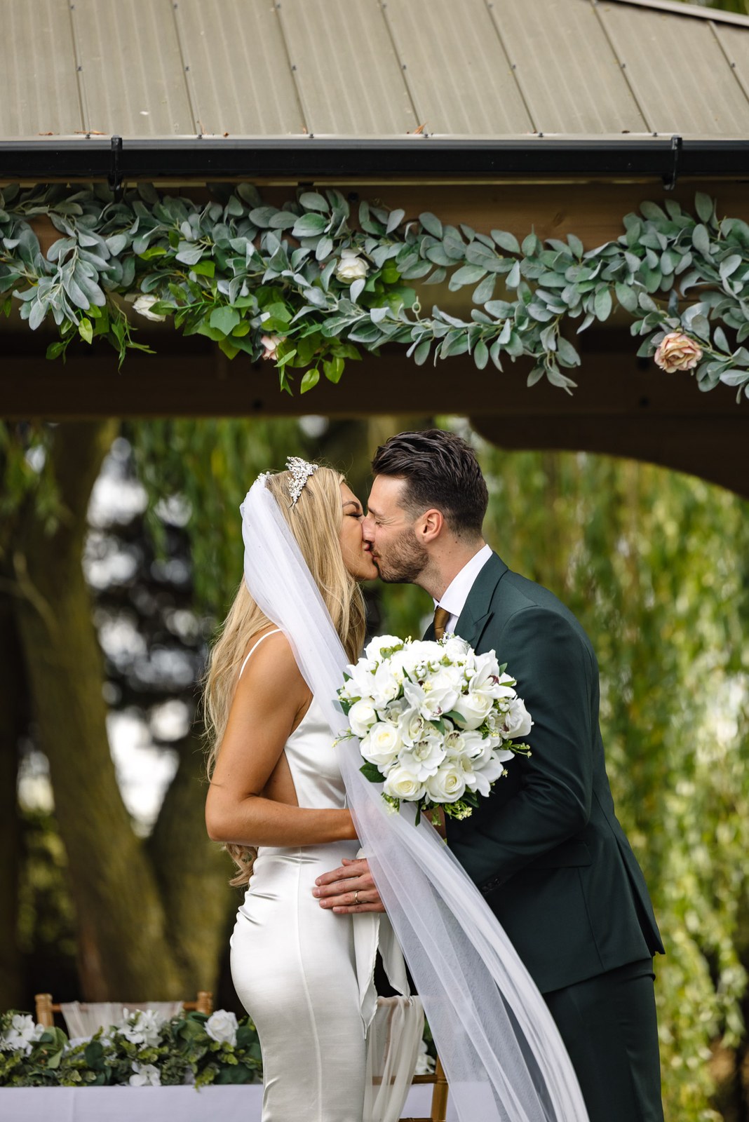 First kiss beneath the greenery-topped gazebo at the Chesterton Hotel