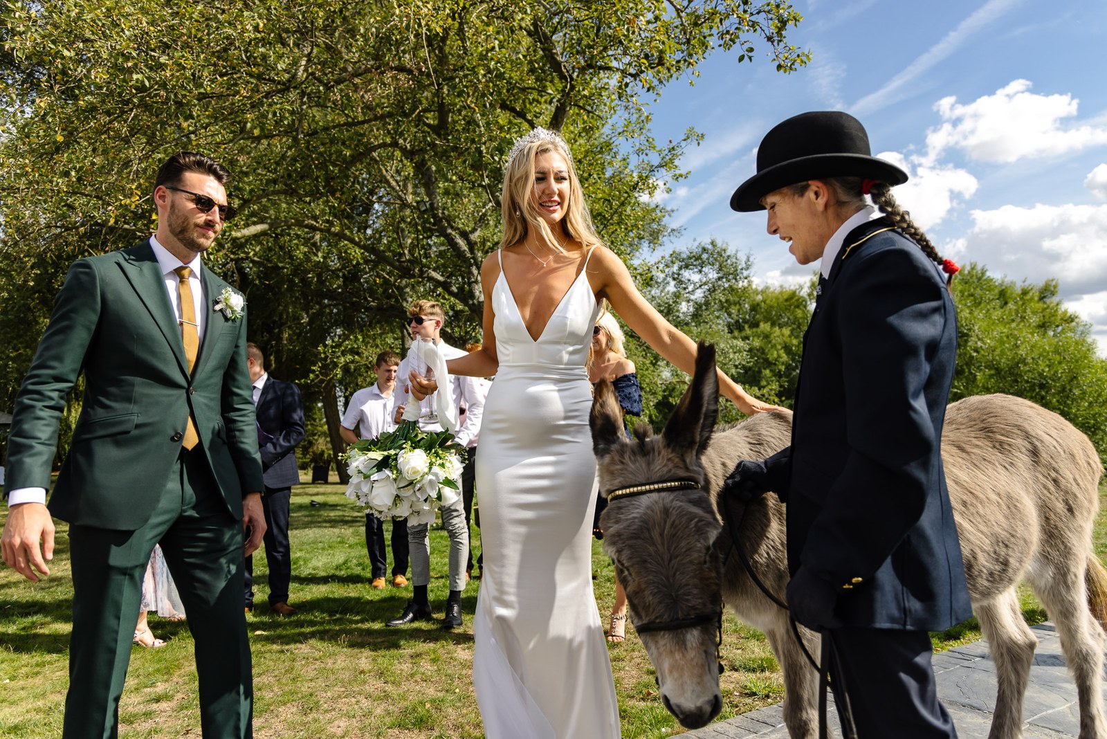 The couple meeting a donkey and its handler on the lawn