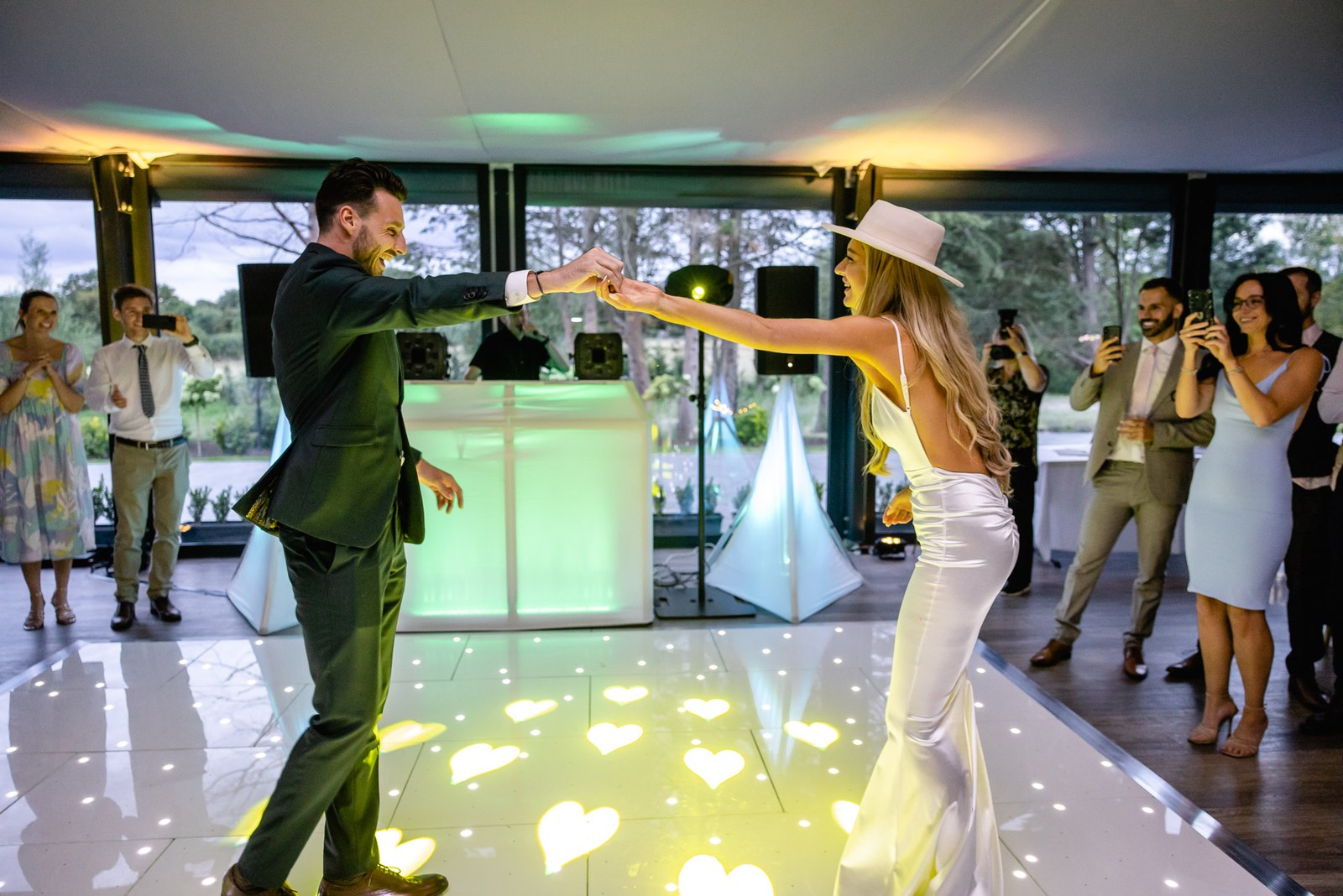 The groom twirling the bride under his arm on the light-up dancefloor