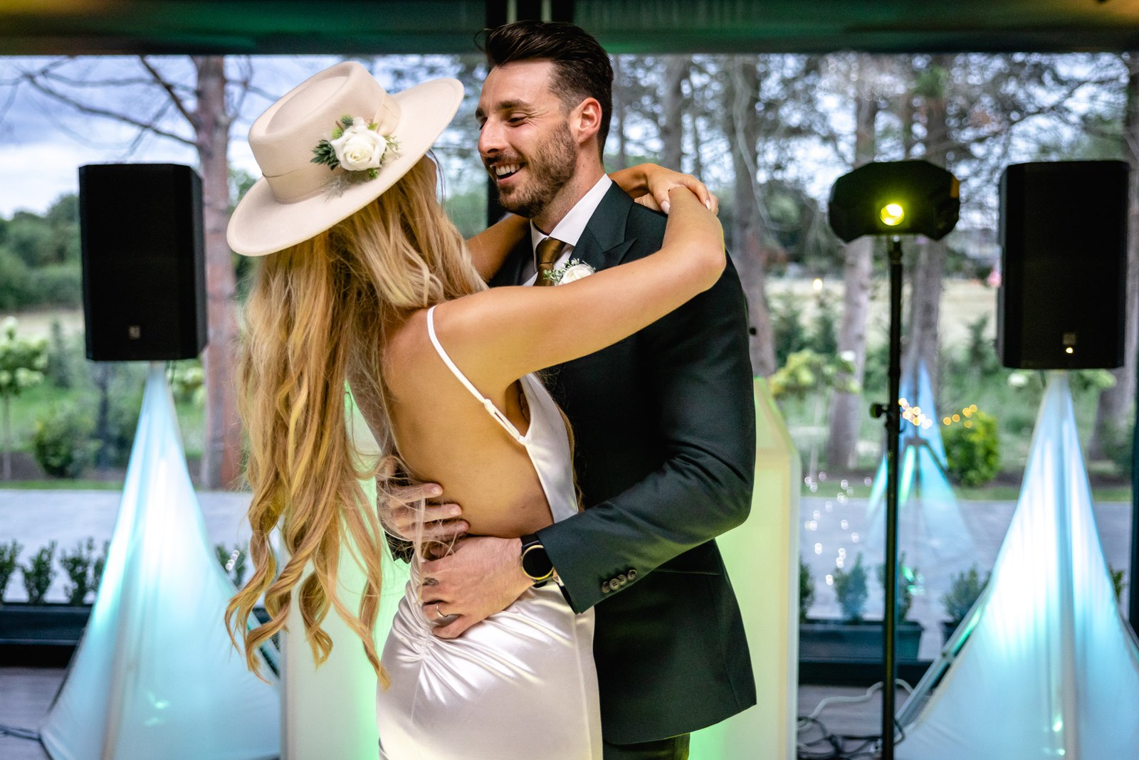 The couple embracing on the dancefloor, the bride in her fedora