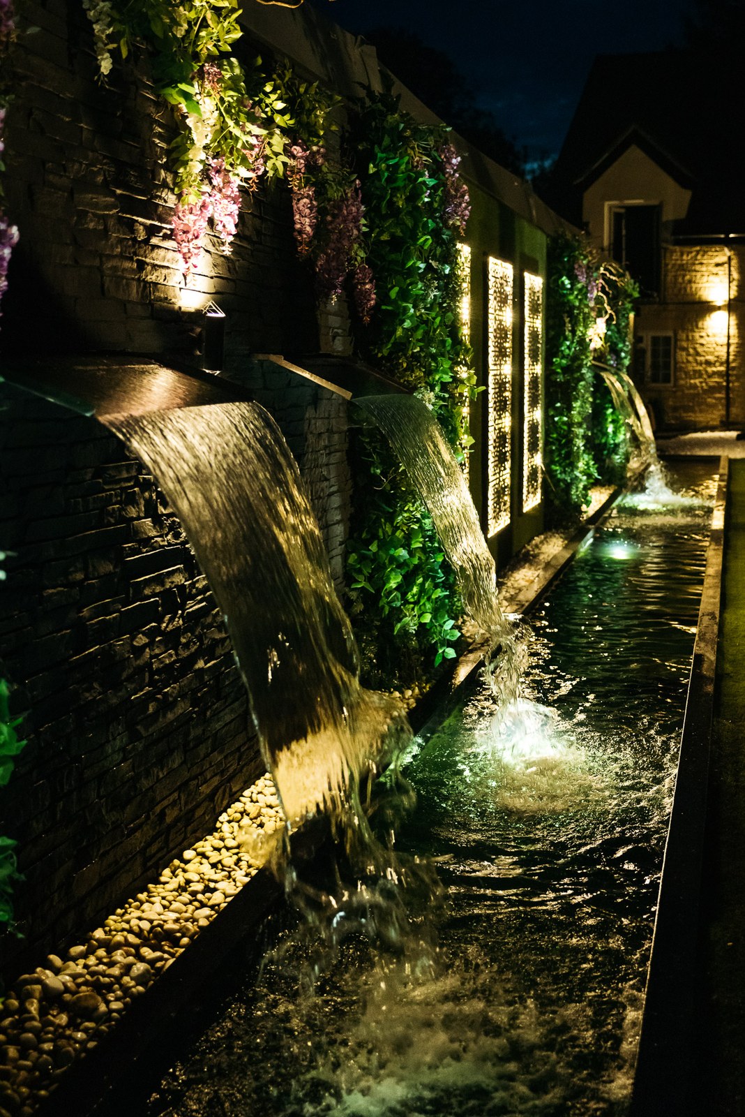 An illuminated water feature in the grounds of the Chesterton Hotel at night
