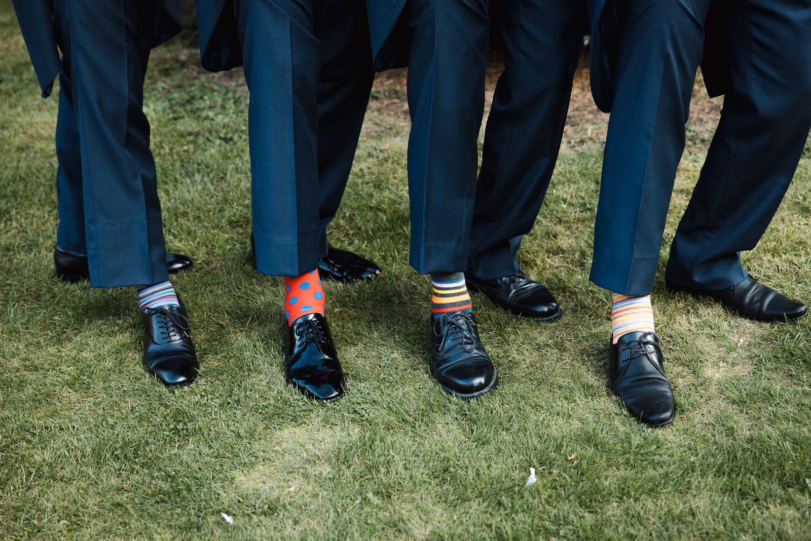 The men's colourful patterned socks on show as they stand on the lawn